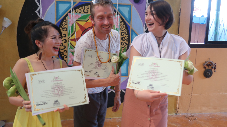 3 students receiving yoga certificate